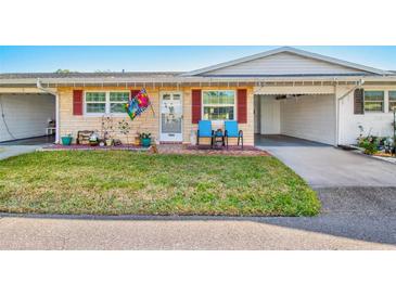 Inviting exterior of a single story home with landscaped lawn and carport at 5005 Lily Street N Pl, Pinellas Park, FL 33782