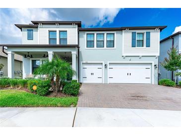 Two-story house with light gray siding, white trim, and a two-car garage at 21361 Snowy Orchid Ter, Land O Lakes, FL 34637