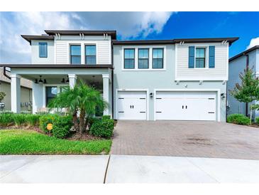 Beautiful two-story home featuring a three-car garage and charming landscaping at 21361 Snowy Orchid Ter, Land O Lakes, FL 34637