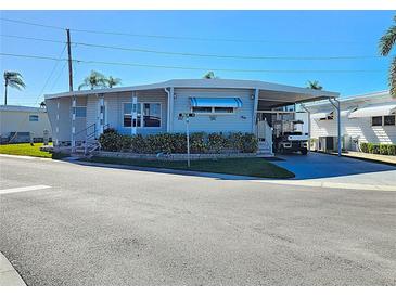 Front exterior of a manufactured home with a carport and landscaping at 34462 Palm N Dr, Pinellas Park, FL 33781