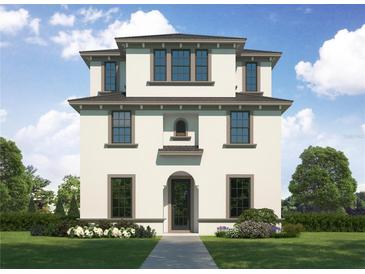 Three-story home with a light-colored exterior, arched entryway, and landscaping at 710 W Frances Ave, Tampa, FL 33602