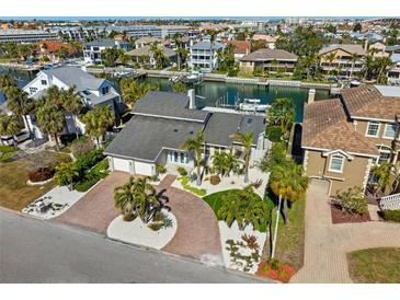Beautifully landscaped home featuring a circular driveway and manicured lawn in a waterfront community at 123 8Th E St, Tierra Verde, FL 33715