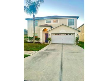 Charming two-story home with a well-manicured lawn, a two-car garage, and a beautiful palm tree at 7423 Pulteney Dr, Zephyrhills, FL 33545