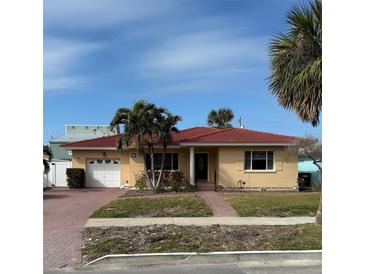 Charming single-story home with a red tile roof, well-manicured lawn, and inviting curb appeal at 988 Bruce Ave, Clearwater Beach, FL 33767