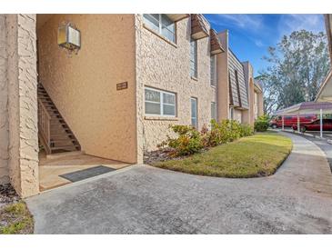 Exterior view of condo building showcasing landscaping and parking at 105 Aspen Cir # 105, Seminole, FL 33777