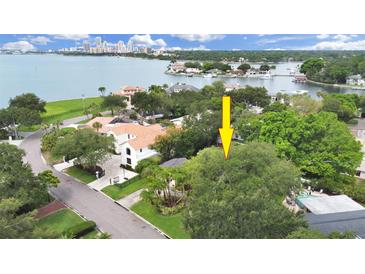 Aerial view of a house with a waterfront lot and lush landscaping at 136 Bay Point Ne Dr, St Petersburg, FL 33704