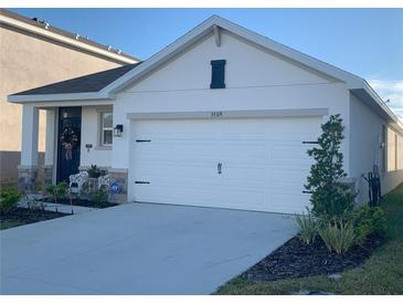 White house with two-car garage and landscaping at 3509 Maple Grove Way, Plant City, FL 33565