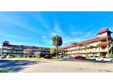 Exterior view of a two-story condominium building with parking lot at 2403 Finlandia Ln # 57, Clearwater, FL 33763