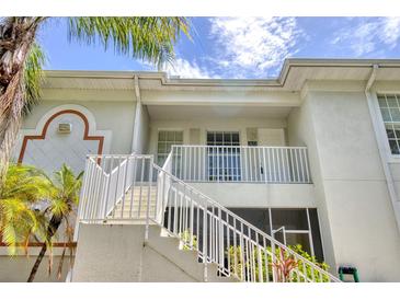 Condo exterior featuring stairs to a private balcony with white railings on a sunny day at 2632 River Preserve Ct, Bradenton, FL 34208