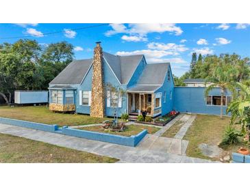 Charming blue home with stone accents, landscaping, and a welcoming front porch at 306 E Paris St, Tampa, FL 33604