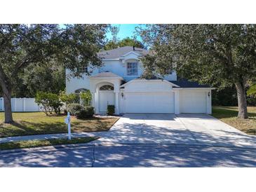 Stunning two-story home with a white exterior, three-car garage, and well-maintained landscaping at 8620 Brookway Cir, Tampa, FL 33635