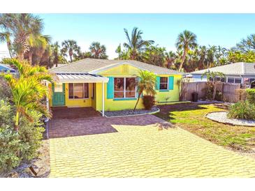 Charming beach house with a carport, teal shutters, and a paver driveway at 504 79Th Ave, St Pete Beach, FL 33706