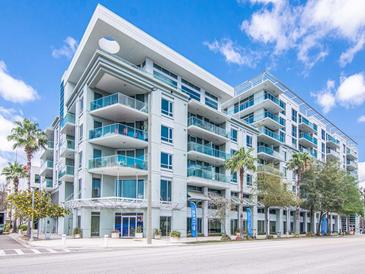 Modern condo building with balconies, palm trees, and street-level businesses at 912 Channelside Dr # 2412, Tampa, FL 33602