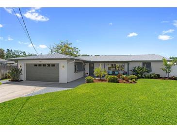 Charming single-story home featuring a well-manicured lawn and a two-car garage at 5101 Huntington Ne Cir, St Petersburg, FL 33703
