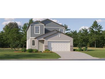 Two-story home with gray and white siding, a white garage door, and landscaping at 9340 Runaway Breeze Dr, Land O Lakes, FL 34637