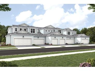 Row of townhouses with garages, light blue siding, and white trim at 17390 Moonflower Dr # 102, Venice, FL 34293