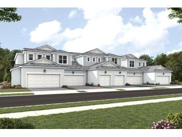 Row of townhouses with garages, light blue siding, and white trim at 17390 Moonflower Dr # 202, Venice, FL 34293