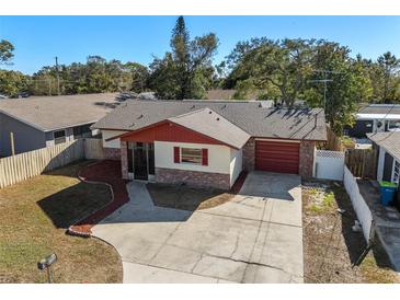 Charming single-story home with red roof, brick facade, and attached garage at 2233 Curlew Rd, Dunedin, FL 34698