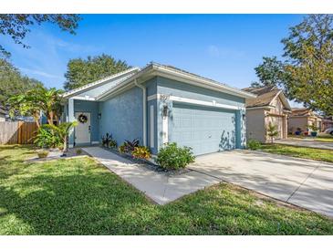 Charming blue home with attached two-car garage and landscaped front yard at 6937 Exeter Park Pl, Apollo Beach, FL 33572