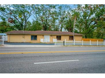 Single-story home with white picket fence and paved driveway at 703 W Sligh Ave, Tampa, FL 33604