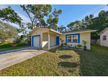Updated bungalow with a freshly painted exterior, new landscaping, and a bright blue garage door at 7471 35Th N St, Pinellas Park, FL 33781