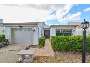 Charming single-story home with attached garage and landscaped walkway at 460 S Woodlands Dr, Oldsmar, FL 34677