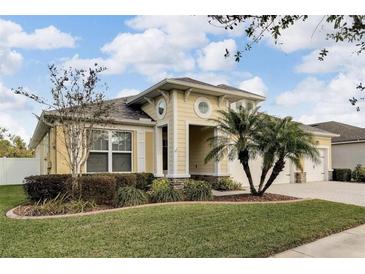 House exterior featuring a two-car garage and manicured landscaping at 12316 Juniper Field Ct, Riverview, FL 33579