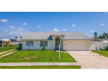 Charming single-story home with a welcoming front yard and attached garage at 13346 Carter Ave, Port Charlotte, FL 33981