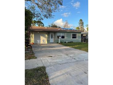 Ranch-style house with a green exterior, driveway, and lawn at 1787 Shore Acres Ne Blvd, St Petersburg, FL 33703