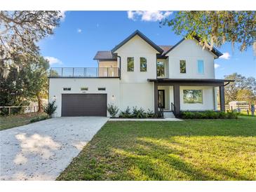 Stunning two-story home with balcony, large windows, well manicured lawn, and attached two car garage at 6303 Barton Rd, Plant City, FL 33565