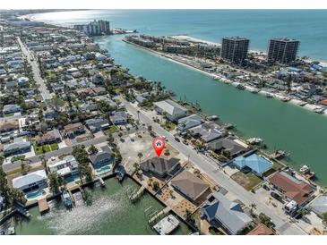 Aerial view of a waterfront home with dock and nearby amenities at 8021 Coquina Way, St Pete Beach, FL 33706