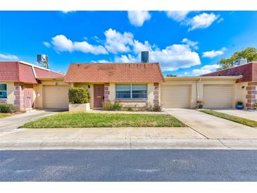 Attached one-story home with one-car garage and landscaped front yard at 8465 Calais N, Pinellas Park, FL 33781