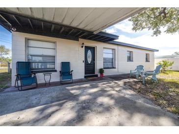 House exterior with carport, landscaping, and seating area at 6019 N Clark Ave, Tampa, FL 33614