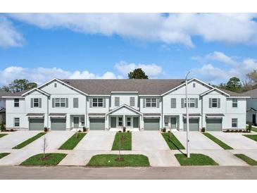 Charming townhome with attached garages, gray shutters, and a beautifully landscaped front yard at 11770 Blackbrook Ct, Seffner, FL 33584