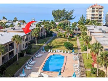 Aerial view of condo community showing building, pool, and surrounding landscape at 19725 Gulf Blvd # 10, Indian Shores, FL 33785