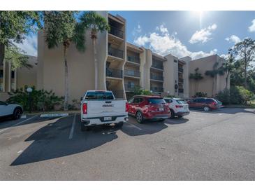 Exterior view of apartment building with ample parking at 90 S Highland Ave # 416, Tarpon Springs, FL 34689