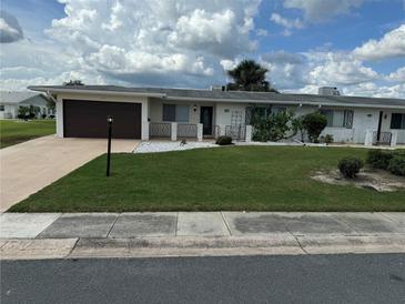 Ranch-style home with a one-car garage and well-manicured lawn at 1517 Danbury Dr, Sun City Center, FL 33573