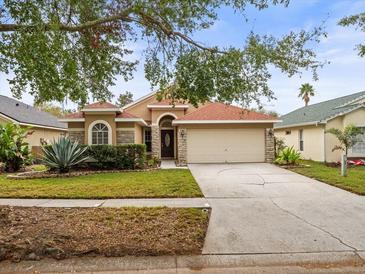 Single-story house with a red tile roof, stone accents, and a two-car garage at 4530 Perdita Ln, Lutz, FL 33558