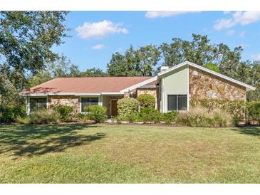 Single-story home with stone exterior and landscaped lawn at 902 Flatwood Ct, Brandon, FL 33511