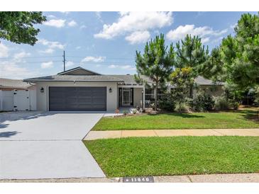 Charming single-story home with gray garage and well-manicured lawn at 11040 126Th Ter, Largo, FL 33778