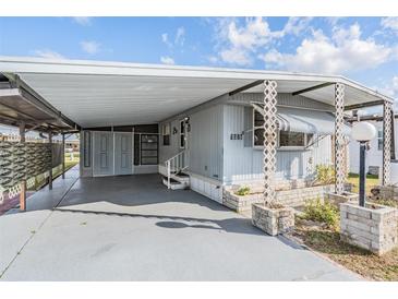 Mobile home exterior features carport and landscaping at 5318 Astrid Dr, Zephyrhills, FL 33541