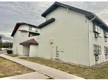 Exterior shot of building with gray trim and pale siding and a sidewalk at 1254 E 113Th Ave # C110, Tampa, FL 33612