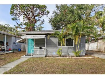 Gray house with teal door, palm trees, and a small yard at 2901 Dr Martin Luther King Jr S St, St Petersburg, FL 33705