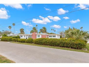 White and red brick mid-century modern home with a landscaped yard at 204 163Rd Ave, Redington Beach, FL 33708