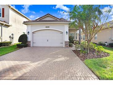 House exterior featuring a brick driveway and a two-car garage at 2756 Tarragona Way, Wesley Chapel, FL 33543