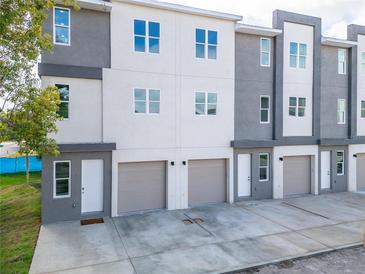 Modern three-story townhouses with attached garages and ample parking at 3450 Desert Trunk Ct, Tampa, FL 33614