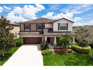 Two-story house with brown roof, tan and white siding, and a two-car garage at 5308 105Th E Ter, Parrish, FL 34219