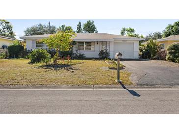 Ranch-style home with a spacious yard and driveway at 7060 40Th N Ter, St Petersburg, FL 33709