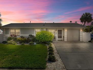 Cute ranch home with a well-manicured lawn and attached garage at 709 Mandalay Ave, Clearwater Beach, FL 33767