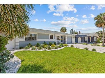 Charming single-story home with beautiful landscaping and a well-manicured lawn at 709 Mandalay Ave, Clearwater Beach, FL 33767
